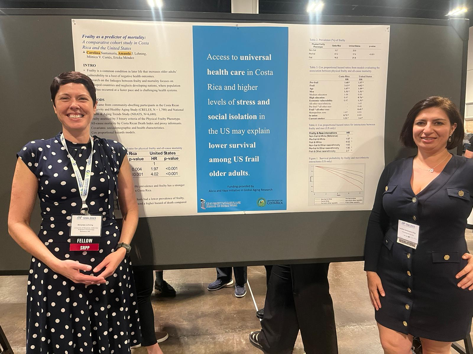 Two women stand by their poster.