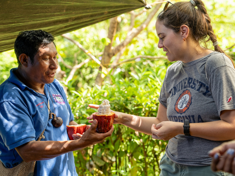 An man hands a woman a cacao pod in Costa Rica