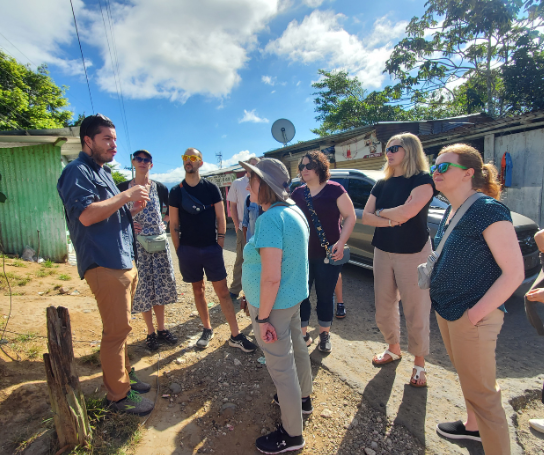 A group of people listen to a speaker outside in Costa Rica