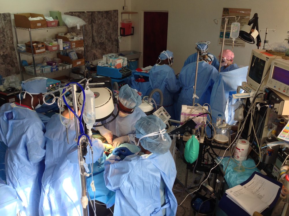 Groups of surgeons perform surgery on two people