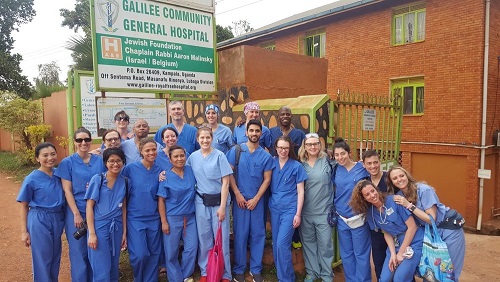 A group of medical professionals poses in front of a sign