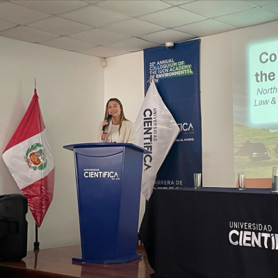 A student speaks at a podium at a colloquium in Peru
