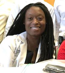 Headshot of woman wearing white medical jacket