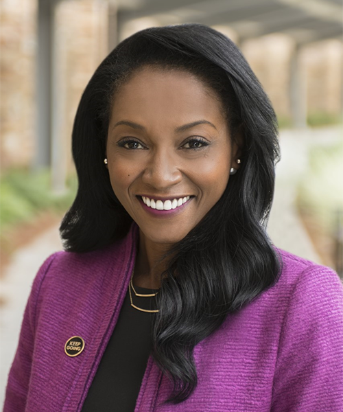 Headshot of a woman in a purple suit jacket