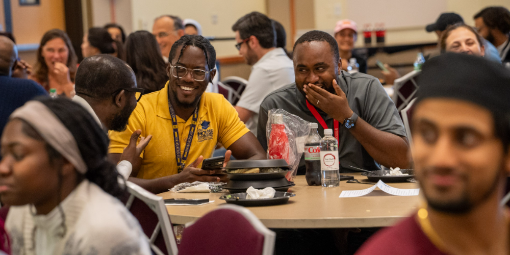 Students sit at a table laughing
