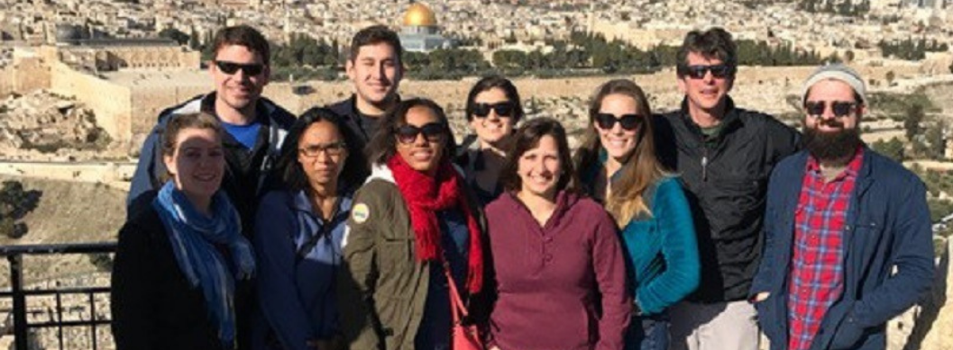 Group of students with a city behind them