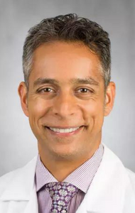 Headshot of a man in a medical jacket