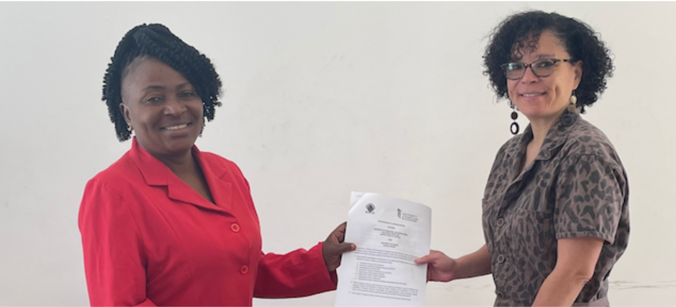 Two women hold a piece of paper between them