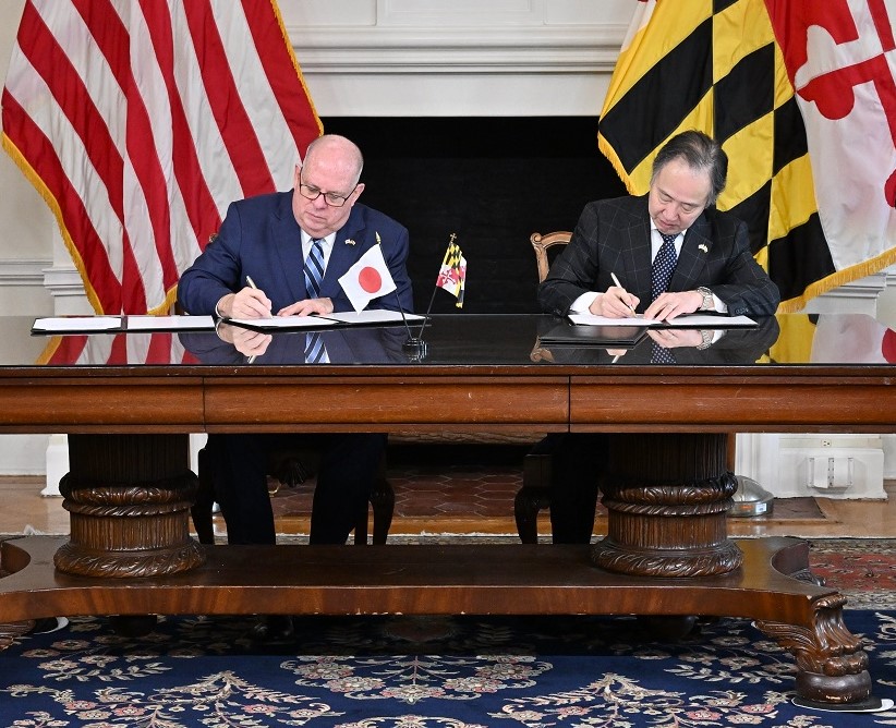 Gov. Hogan and Japanese Ambassador sign an agreement at a large ceremonial desk