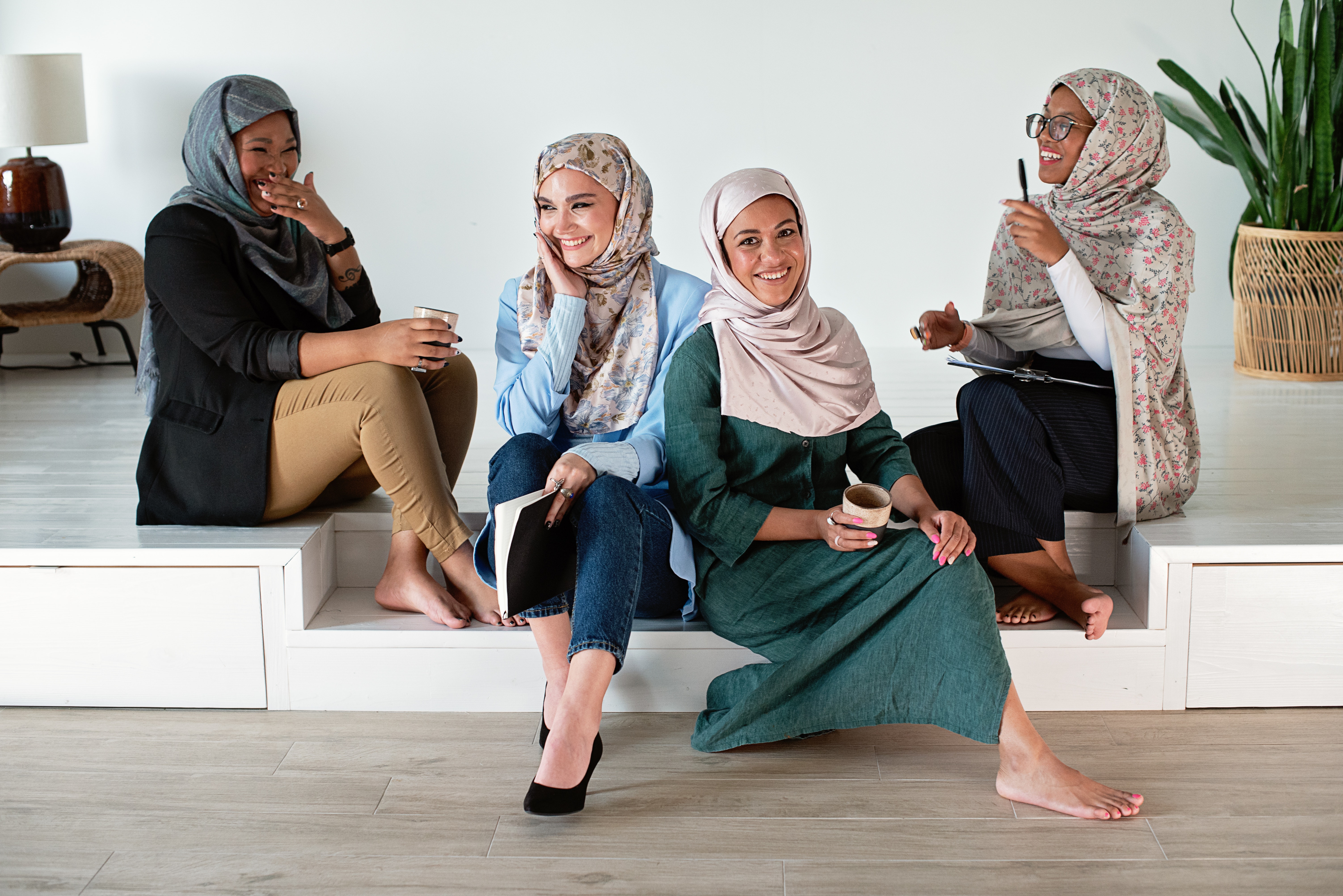 Women wearing hijabs sit on stairs