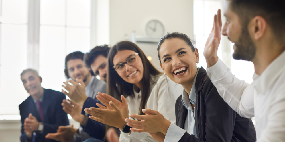 An employee is applauded by his peers