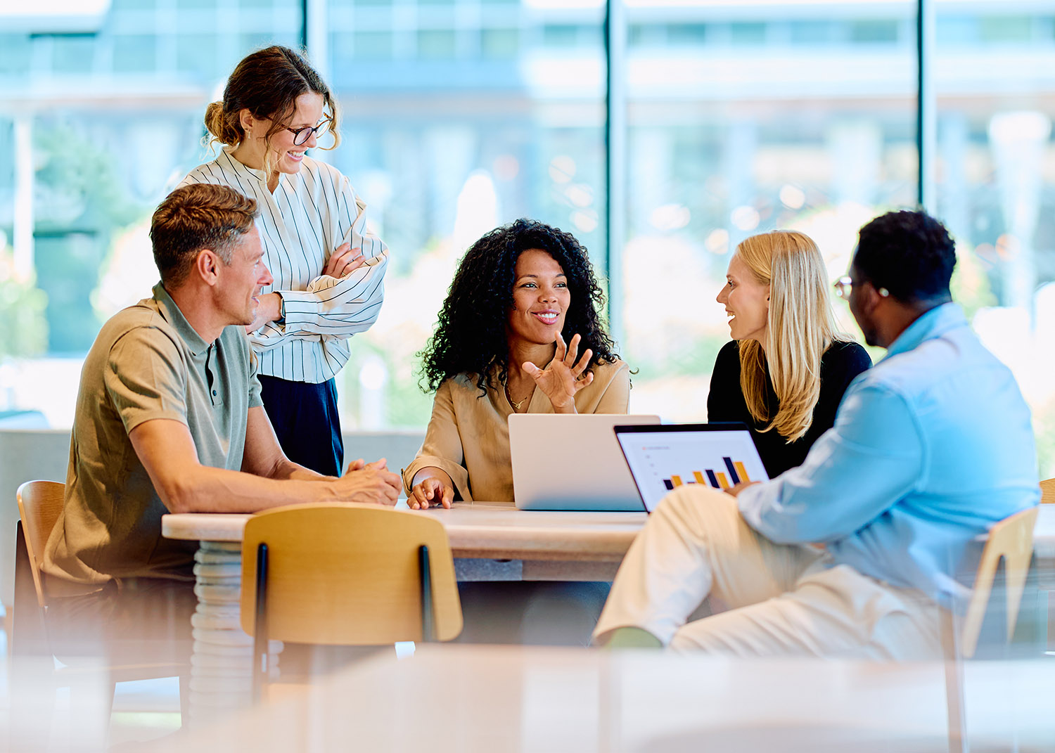 a diverse group of professionals have a conversation around a table