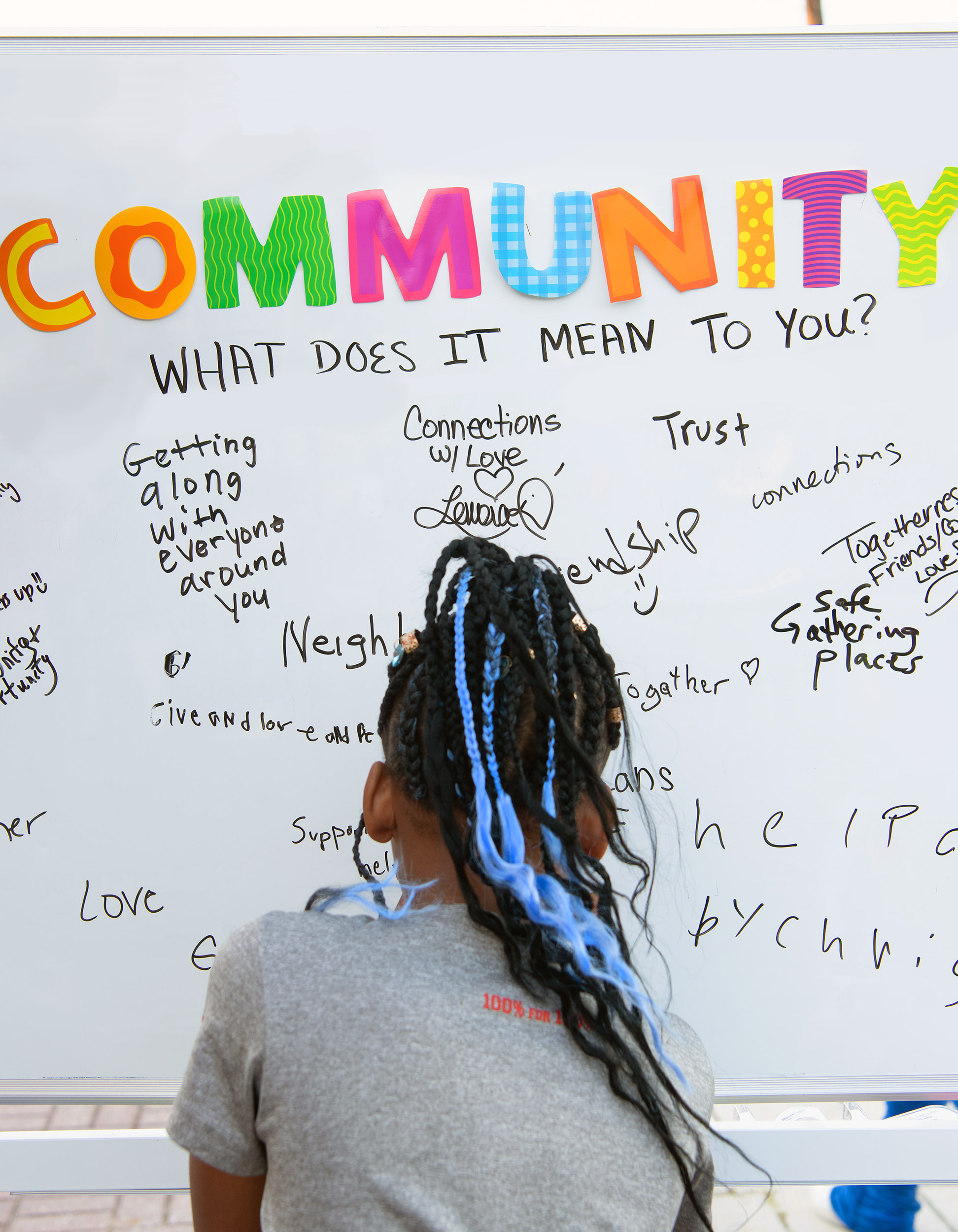 little girl writes a message on a white board about 