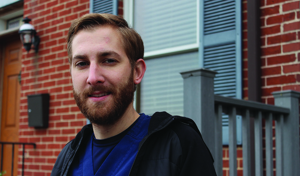 Man standing in front of Baltimore row home