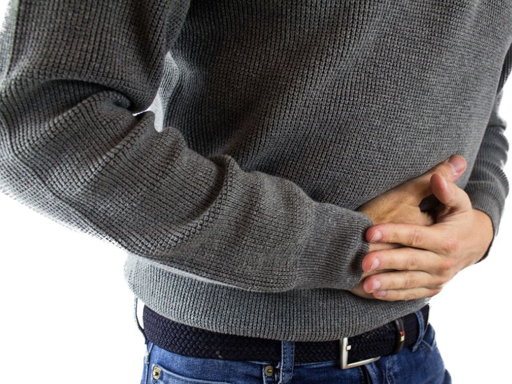 a man holding his hands over his belly