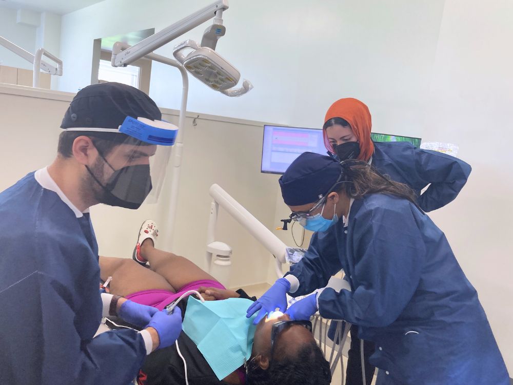 Dr. Halima Karim (center) supervises dental students at the spring Mission of Mercy clinic.