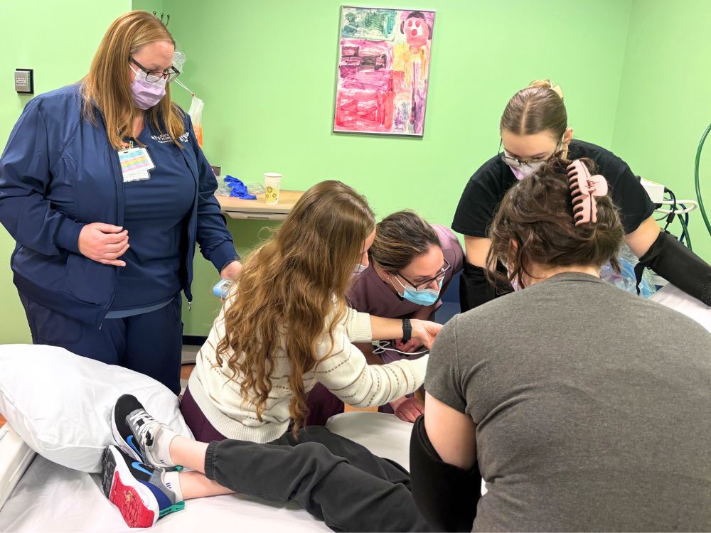 Erica Caffrey, DDS, (Center) performs a dental exam on a patient at Kennedy Krieger.