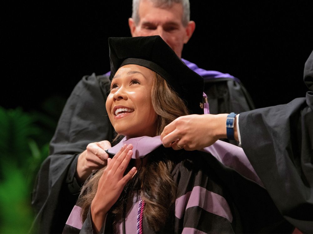 A dental graduate is hooded at the 2026 honors convocation
