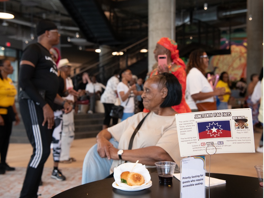 Attendees gather around tables to enjoy food and conversation at UMB's Juneteenth Jubilee.
