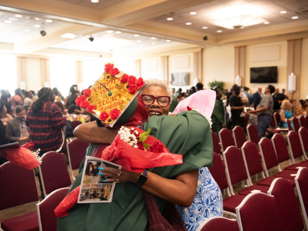 Keyia Brown, a UMB employee who was enrolled in the Goodwill Excel Center High School Diploma Program, hugs Dawn Rhodes, DBA, chief business and finance officer and senior vice president of the Office of Administration and Finance.