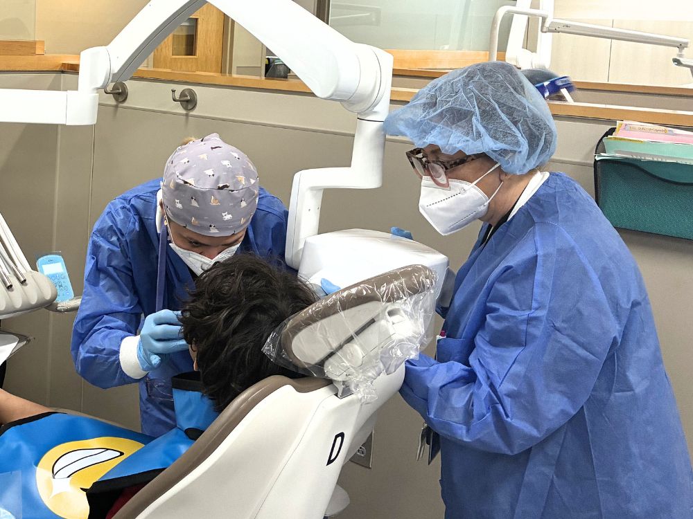 Dr. Shari Kohn (right) assists fourth-year dental student Jamie Derkasch with an X-ray in the pediatric dental clinic.