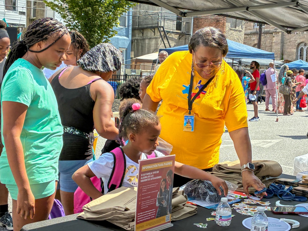 A girl selects stickers and supplies from the Baltimore City Public Schols table at the fifth annual Back-to-School Bash. Photo by Charles Schelle
