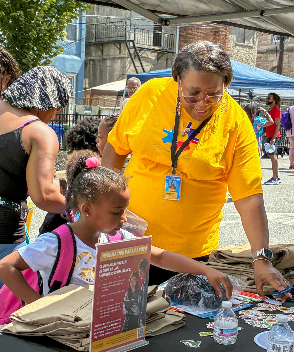 A girl selects stickers and school supplies at a table during the fifth annual Back-to-School Bash.
