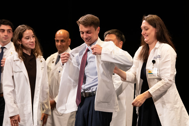 A member of the University of Maryland School of Medicine Class of 2030 receives his first white coat during the Aug. 7 ceremony at the Hippodrome Theatre.