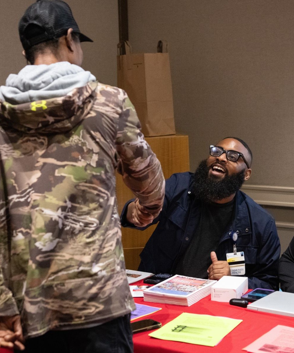 A returning citizen connects with a community partner during an EMBRACE resource fair in West Baltimore.