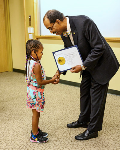 Dean E. Albert Reece presents a diploma at Mini-Med School for Kids.