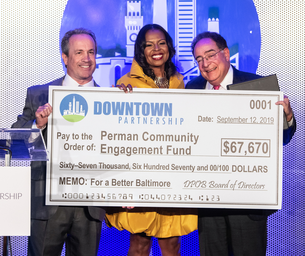 Kirby Fowler, Shelonda Stokes and Jay Perman hold a ceremonial check for the Perman Community Engagement Fund 