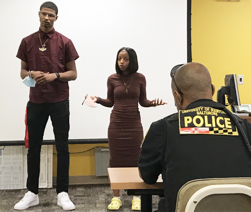 Healing Youth Ambassadors Shelah Johnson and Jima Chester speak to UMB Police in July 2021.