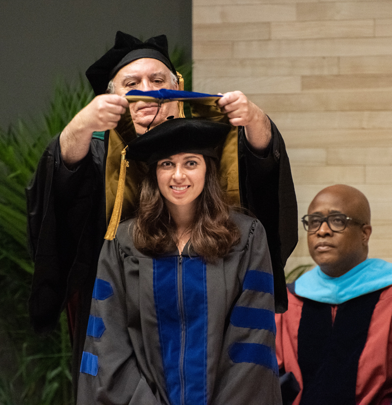 Graduate Ava Zapf, PhD '22, is hooded by mentor Paul Welling, MD.