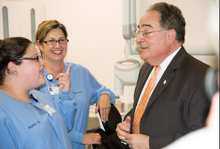 President Jay A. Perman, MD, talks with dental assistants Sophie Paulsgrove and Rebecca Howes at the Monocacy Health Partners Dental Clinic in Frederick.