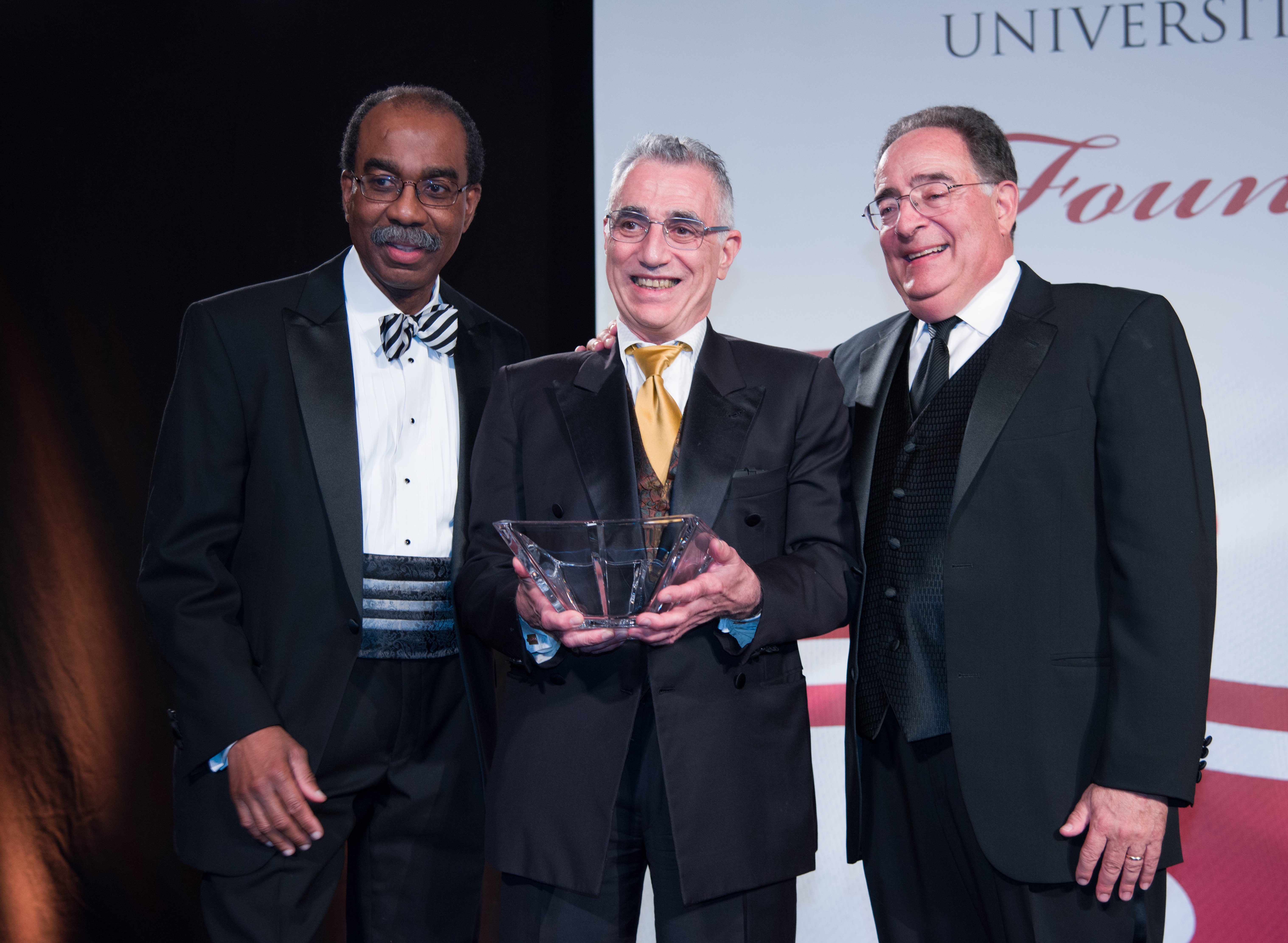 Dr. Thomas Scalea accepts the Entrepreneurs of the Year award on behalf of MARS team members Deborah Stein and Steven Hanish, flanked by School of Medicine Dean E. Albert Reece and UMB President Jay A. Perman.