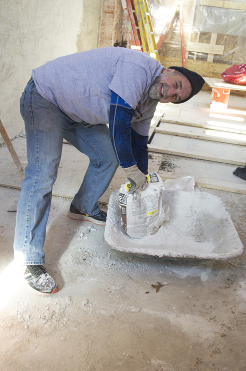 Richard P. Barth, PhD, MSW, dean of the University of Maryland School of Social Work, helps to make a cement mixture at the project site on Presstman Street.