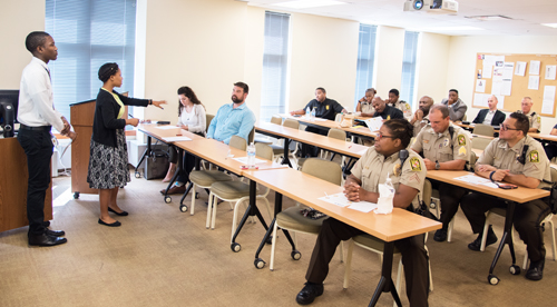 Taylor Owens of Baltimore Polytechnic Institute addresses UMB police officers on Zika virus issues as classmate Vernon Stepney looks on.