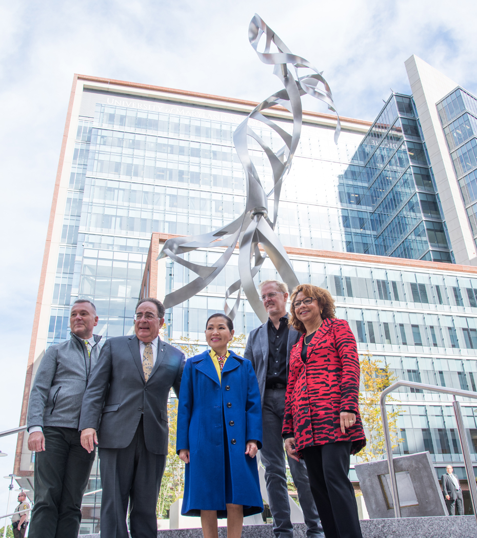 From left, Ken Skrzesz, executive director of the Maryland State Arts Council; UMB President Jay A. Perman; Maryland First Lady and artist Yumi Hogan; sculptor Eric Peltzer; and Catherine Leggett, chair of the Maryland Commission on Public Art, stand in front of UMB's first public art after its dedication.