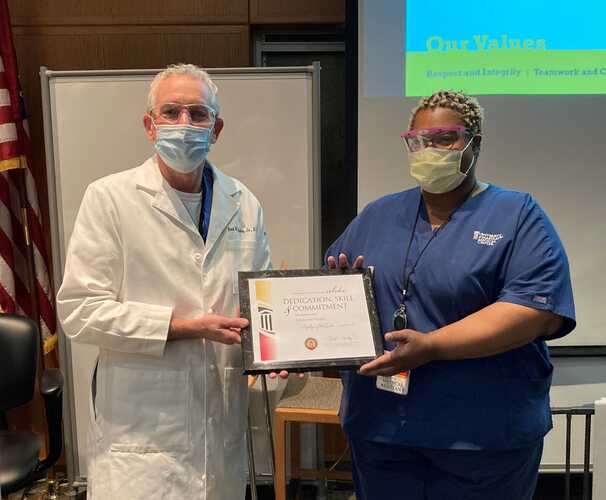 Bert O’Malley, MD, the president and chief executive officer of the University of Maryland Medical Center, presents Telisha McDonald with a plaque naming her Employee of the Quarter.