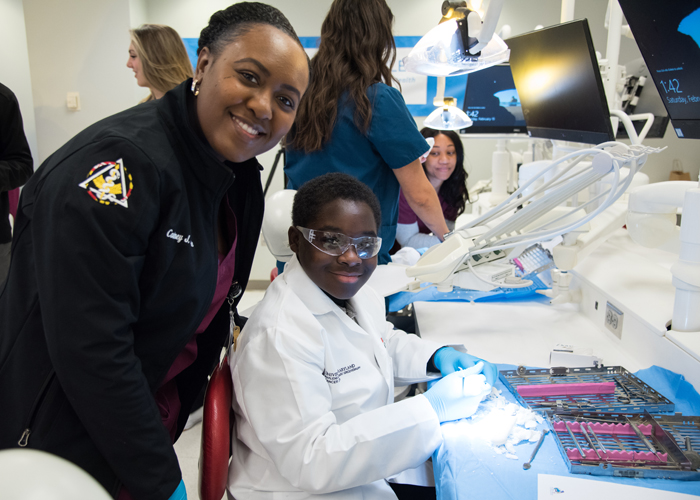 Earold Farquharson, a CURE Scholar in cohort 5 (right), works with his mentor, Courtney Kane, a Class of 2023 student at the School of Dentistry, to carve a tooth mold out of a soap bar. 
