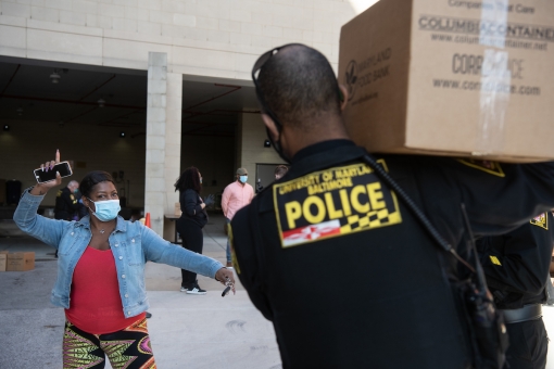 Erika Malone, the mother of UMB CURE Scholar Emani Malone, picks up food at the Intercultural Center’s Pop-Up Pantry with the help of UMB Police Officer Yale Partlow. (Matthew Paul D’Agostino/UMB Staff Photo)