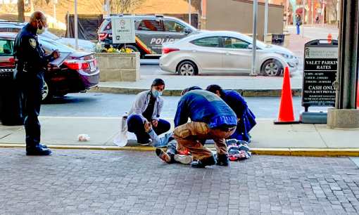 University of Maryland, Baltimore Deputy Director of Emergency Management Christopher Stanton, MS, crouches at the feet of a gunshot wound victim using a Stop the Bleed kit on March 15 as others assist. 