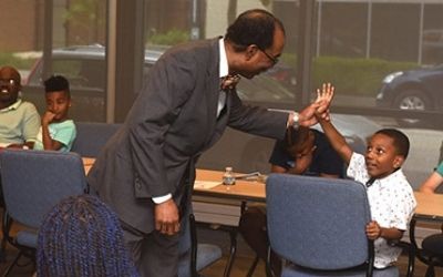 Dean Reece gives a high-five of encouragement to a student in the Mini-Med School for Kids Program. 