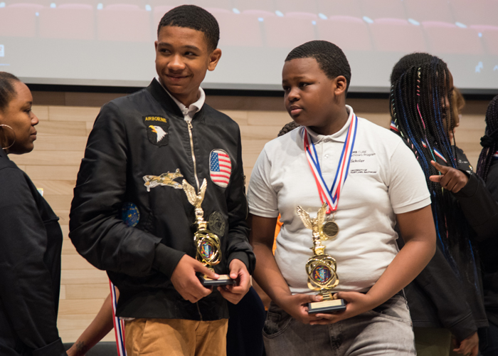 Khamari Stubbs (left), a Cohort 4 CURE Scholar, and Jaylen Galmore, a Cohort 3 CURE Scholar, accept their trophies for coming in first place at the 2019 CURE STEM Expo in the anatomy curriculum category.