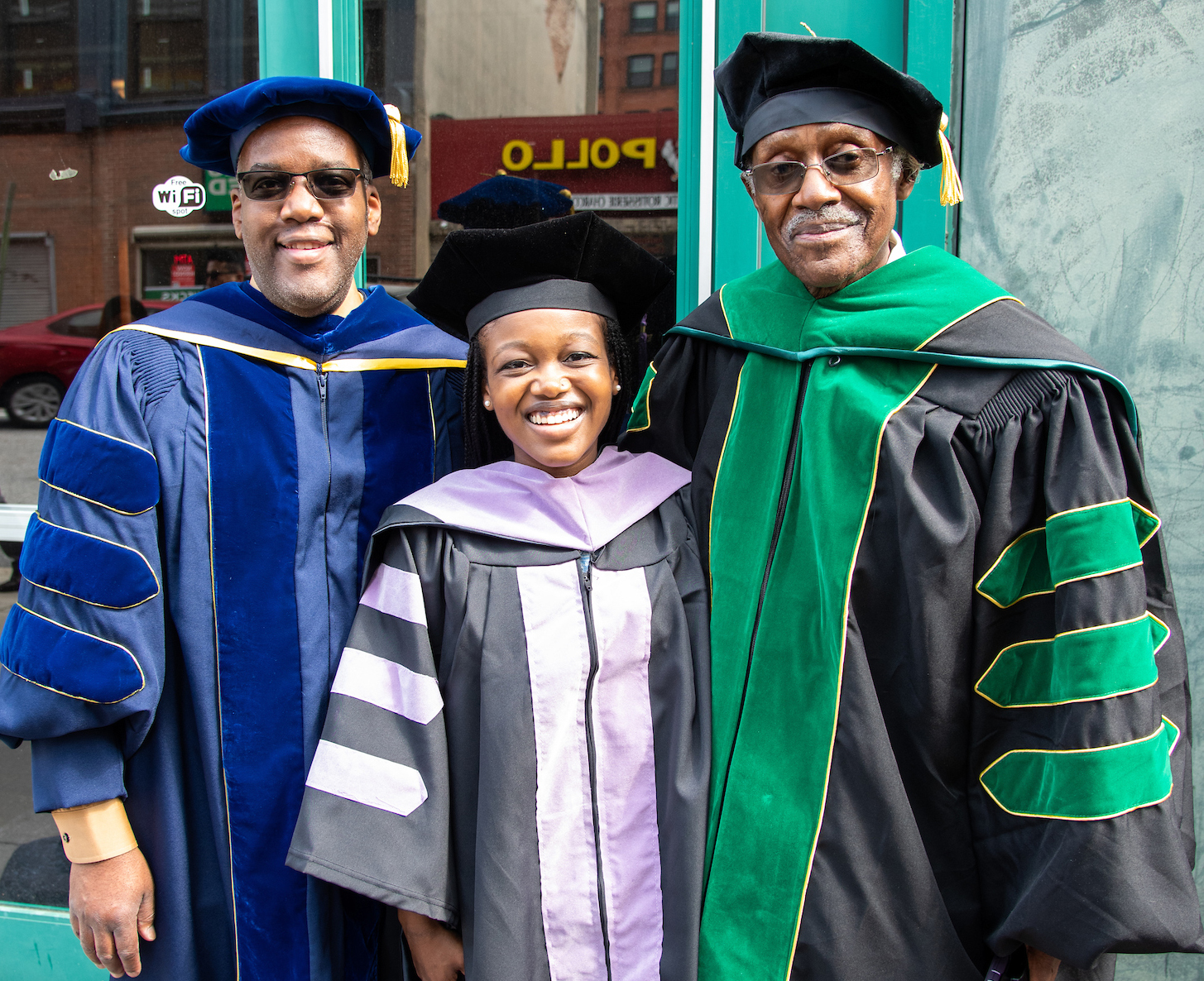 Sarah Nia Coleman, DDS ’22  (center), was hooded by her father Charles Coleman, PhD (left), and her grandfather William Brown, MD (right).