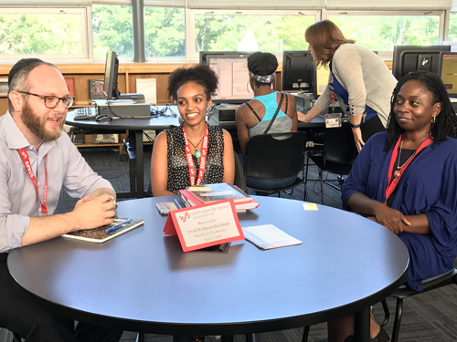 University of Maryland School of Social Work students Shlomo Goldberger (left) and Sara Haile (center) give faculty clinical instructor Kimberly Street an update on their participation in the new Social Worker in the Library program, which places social work students in Baltimore libraries to provide social services to patrons.