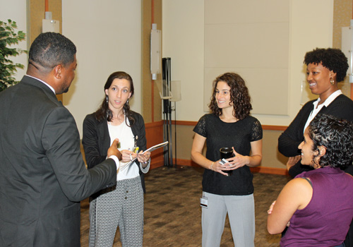 UMB President’s Fellows (from left) Nicole Campion Dialo, Jessica Egan, Lauren Highsmith, and Vibha Rao chat with Capt. T.J. Smith after his presentation.
