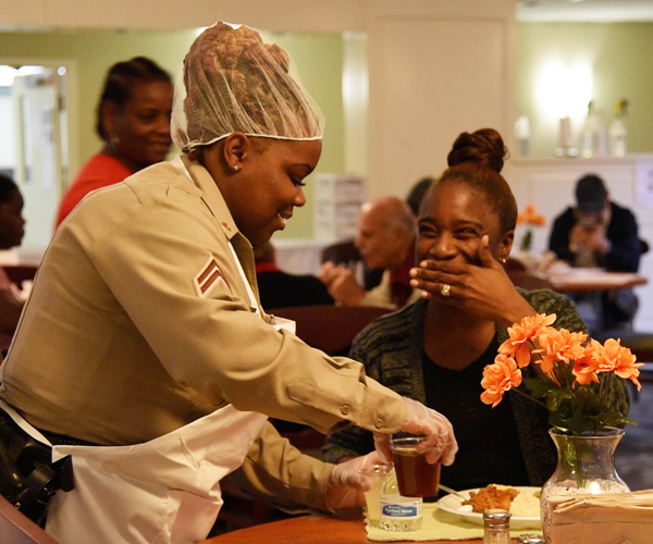 Hazel Lewis (left), a corporal for the UMB Police Force, serves drinks to guests at the American Cancer Society's Hope Lodge of Baltimore during dinner. 