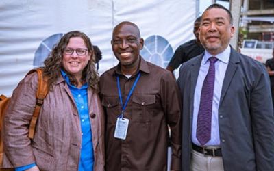 Kristen Stafford, PhD, MPH, left, and Man Charurat, PhD, MHS, right, stand with Segun Akanmu of IHV-Nigeria at the recently launched multi-campus of excellence in public health care, treatment training, and research.
