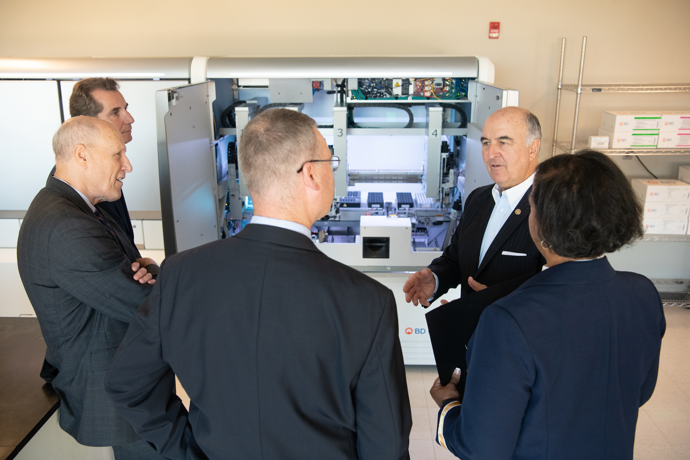 Maryland Commerce Secretary Mike Gill engages in conversation with UMB President Bruce E. Jarrell, MD, FACS, and BD executives Nikos Pavlidis, Adam Steel, and Brooke Story during a tour of the BD Innovation Center.